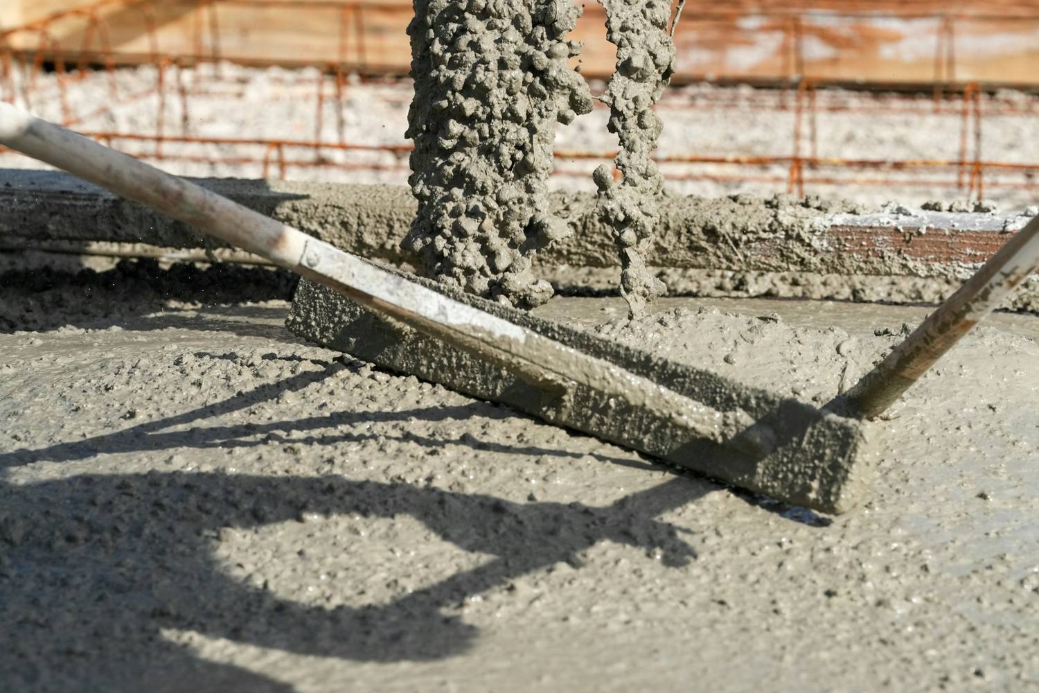 Wet concrete being placed over rebar and screeded flat