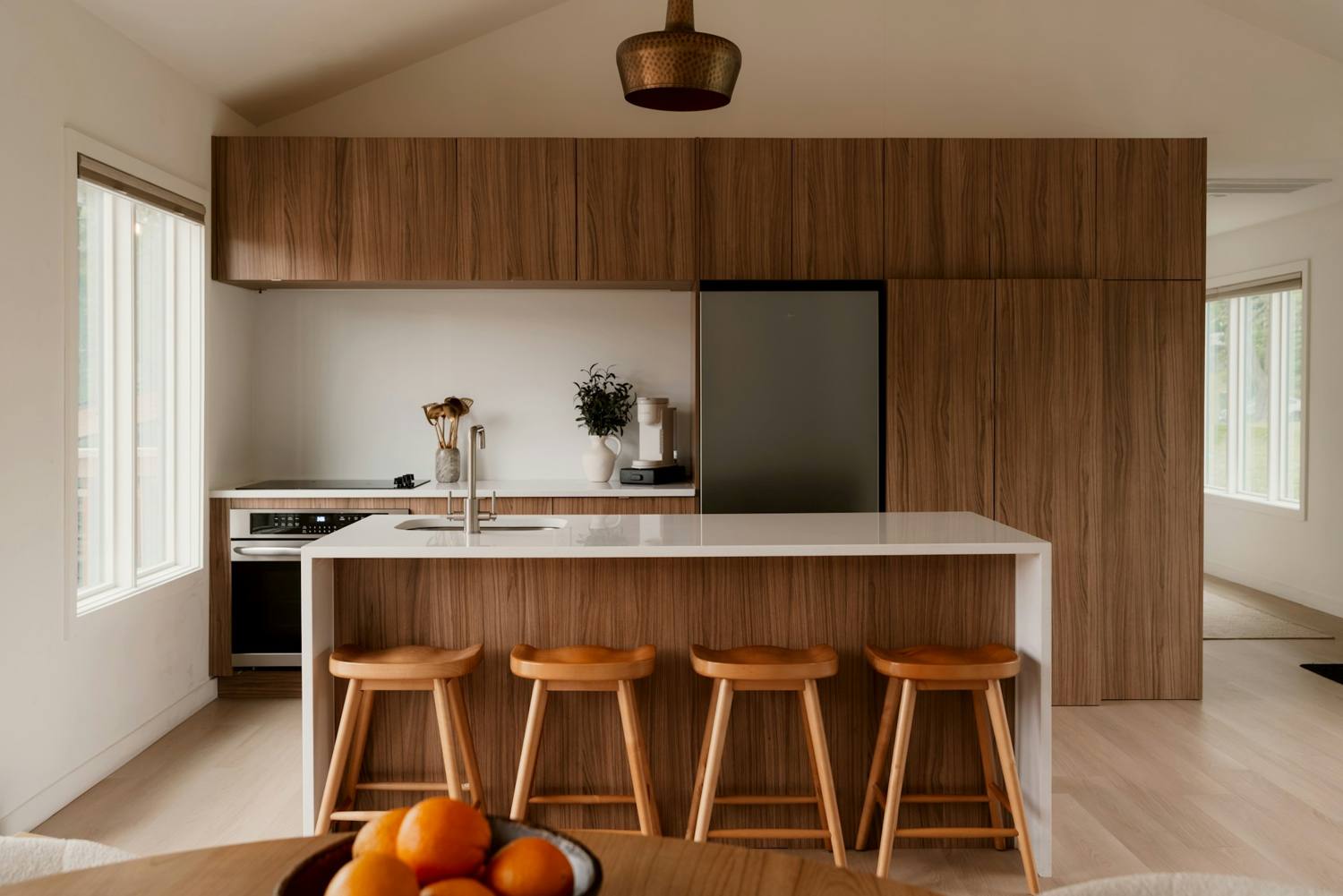 Walnut kitchen with a white waterfall countertop running down the island