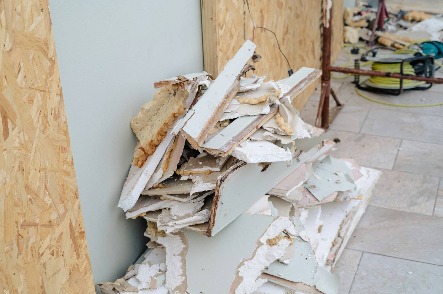 Torn-out drywall and framing stacked inside a gutted room