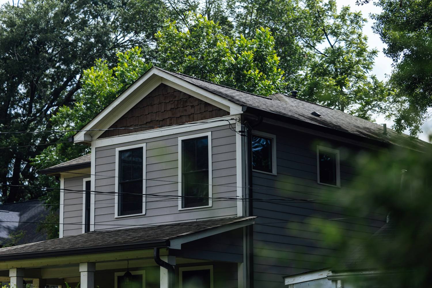 Two-story house with white-trimmed double-hung windows and gray lap siding